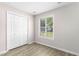 Neutral bedroom boasts wood-look floors, double closet and a bright window with natural light at 2233 Alpine Rd, Durham, NC 27707