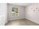 Cozy bedroom with new light wood flooring, neutral paint, large window, and built in closet at 2233 Alpine Rd, Durham, NC 27707