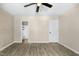Bedroom features wood-look floors, ceiling fan, view to bathroom, and an accent wall at 2233 Alpine Rd, Durham, NC 27707