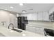 Well-lit kitchen featuring white cabinets, granite countertops, stainless steel appliances, and modern fixtures at 2233 Alpine Rd, Durham, NC 27707
