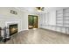Inviting living room featuring wood floors, fireplace, fan and access to backyard at 2233 Alpine Rd, Durham, NC 27707