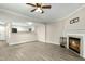 Inviting living room featuring wood floors, fireplace, fan and access to kitchen at 2233 Alpine Rd, Durham, NC 27707