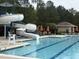 Inviting community pool featuring a water slide, lounge chairs, and umbrellas for a relaxing day at 2361 Rainy Lake St, Wake Forest, NC 27587