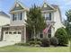 Beautiful two-story home with a stone facade, complemented by a lush lawn and a patriotic American flag at 2361 Rainy Lake St, Wake Forest, NC 27587