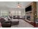 Cozy living room showcasing a stone fireplace, plush sectional sofa, and plenty of natural light at 2361 Rainy Lake St, Wake Forest, NC 27587