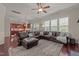 Spacious living room featuring an oversized sectional couch, ceiling fan, and abundant windows at 2361 Rainy Lake St, Wake Forest, NC 27587