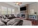 Spacious living room with a striking stone fireplace, mounted TV, and comfortable sectional sofa at 2361 Rainy Lake St, Wake Forest, NC 27587