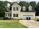 Two story home with attached two car garage, front porch, and fire damage at 2377 Vinson Rd, Clayton, NC 27527