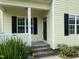 Close-up of front porch with brick steps, white columns, black door, and the house number 2377 above the door at 2377 Vinson Rd, Clayton, NC 27527