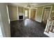 Empty living room featuring a decorative fireplace, hardwood floors and natural lighting, needing renovation at 2377 Vinson Rd, Clayton, NC 27527