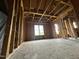 Unfinished room with exposed studs, wooden floors, and a large window, offering renovation potential at 2377 Vinson Rd, Clayton, NC 27527