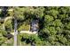 An aerial view of a home nestled among mature trees, showing the roofline and the surrounding verdant landscape at 2409 Beechview Ct, Raleigh, NC 27615