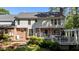 Charming two-story home featuring a spacious deck, lush landscaping, and a mix of brick and siding at 2409 Beechview Ct, Raleigh, NC 27615