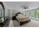 Inviting bedroom with plush bedding, dark wood furniture, and natural light from large windows at 2409 Beechview Ct, Raleigh, NC 27615