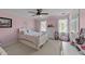 bedroom with pink walls, hardwood floors, light color accents, and natural light from the windows at 2409 Beechview Ct, Raleigh, NC 27615