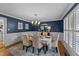 Elegant dining room with a decorative chandelier, seating for six, and dark blue accent wall at 2409 Beechview Ct, Raleigh, NC 27615