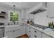 Bright kitchen featuring a gas range, farmhouse sink, and herringbone backsplash at 2409 Beechview Ct, Raleigh, NC 27615