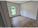 Bright bedroom features woodgrain flooring and a window with view to green outdoor space at 2668 Bodie Currin Rd, Oxford, NC 27565