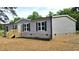 Inviting single-story home displays gray siding, black shutters, a delightful front porch and neat landscaping at 2668 Bodie Currin Rd, Oxford, NC 27565