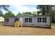 Attractive single-story home showcasing gray siding, black shutters, a cozy front porch and well-maintained grounds at 2668 Bodie Currin Rd, Oxford, NC 27565