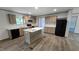 Well-lit kitchen features an island with a white countertop, modern appliances, and stylish wood-look vinyl flooring at 2668 Bodie Currin Rd, Oxford, NC 27565