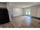Spacious living area with wood-look vinyl floors, ample natural light, and an open layout leading to the kitchen at 2668 Bodie Currin Rd, Oxford, NC 27565