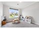 Bright bedroom features natural light from a large window overlooking the grassy backyard and an area with a table and bookcase at 272 High Woods Rdg, Chapel Hill, NC 27517