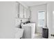 Bright laundry room featuring a modern washer and dryer, utility sink, and storage cabinets at 272 High Woods Rdg, Chapel Hill, NC 27517