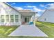 Inviting covered back patio with concrete flooring, comfortable seating, and sliding glass doors to the home's interior at 30 Sawtooth Oak Ln, Youngsville, NC 27596