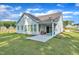 A large backyard featuring a covered patio with outdoor seating and manicured green grass at 30 Sawtooth Oak Ln, Youngsville, NC 27596