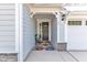 Close up of a charming front porch with seating area and a decorative rug at 30 Sawtooth Oak Ln, Youngsville, NC 27596