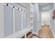 Hallway with a mudroom station featuring built-in shelving and hooks, leading to laundry at 30 Sawtooth Oak Ln, Youngsville, NC 27596