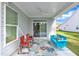 Covered outdoor patio featuring a ceiling fan, bright blue couch, and two red rocking chairs at 30 Sawtooth Oak Ln, Youngsville, NC 27596