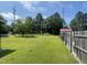 Large, grassy backyard with a wooden fence and storage sheds, offering ample space for recreation at 3301 Amherst Rd, Rocky Mount, NC 27804