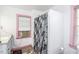 Bathroom featuring a walk-in shower with a gray floral shower curtain, a sink, and a window at 3301 Amherst Rd, Rocky Mount, NC 27804