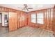 Cozy wood paneled bedroom featuring vinyl floors and ample natural light from the windows at 3301 Amherst Rd, Rocky Mount, NC 27804