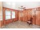 A wood-paneled bedroom with a ceiling fan and natural light showcases a cozy and rustic interior at 3301 Amherst Rd, Rocky Mount, NC 27804