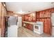 Functional kitchen with classic appliances, wood paneled walls, and modern flooring at 3301 Amherst Rd, Rocky Mount, NC 27804