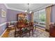 Elegant dining room with a decorative chandelier, hardwood floors, and a large window at 3923 Napa Valley Dr, Raleigh, NC 27612