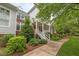 Charming two-story home with a covered front porch, red front door, landscaped yard, and brick and siding exterior at 3923 Napa Valley Dr, Raleigh, NC 27612