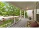 Inviting front porch featuring gray decking, white railings, and a comfortable wicker chair at 3923 Napa Valley Dr, Raleigh, NC 27612