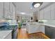 Bright kitchen featuring white cabinets, stainless steel appliances, and an open view to the living area at 3923 Napa Valley Dr, Raleigh, NC 27612