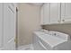 Functional laundry room featuring a side-by-side washer and dryer, and overhead cabinets at 3923 Napa Valley Dr, Raleigh, NC 27612