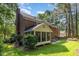 The brick home boasts a screened-in porch and a patio surrounded by mature trees and lush lawn at 4020 Gumleaf Dr, Apex, NC 27539