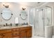 A spacious bathroom features double sinks with granite countertops, wood cabinetry, and glass shower at 4020 Gumleaf Dr, Apex, NC 27539