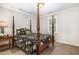 A cozy bedroom featuring a traditional-style, four-poster bed with floral bedding and natural light at 4020 Gumleaf Dr, Apex, NC 27539