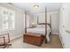 Bright bedroom with a four-poster bed, wooden chest, and shuttered windows provides a comfortable retreat at 4020 Gumleaf Dr, Apex, NC 27539