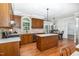 Well-designed kitchen with wooden cabinets, a center island, and views into a bright dining nook at 4020 Gumleaf Dr, Apex, NC 27539
