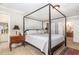 Comfortable main bedroom features a four-poster bed, neutral walls, and an adjoining bathroom at 4020 Gumleaf Dr, Apex, NC 27539