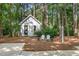 Charming outbuilding nestled among the trees with a decorative wreath on the door and chairs in front at 4020 Gumleaf Dr, Apex, NC 27539